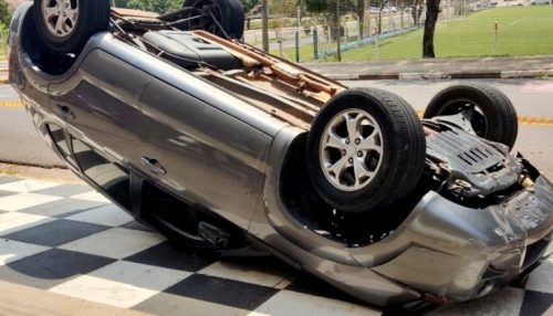 Frentista fica preso embaixo de veículo após mulher capotar carro em posto de combustíveis