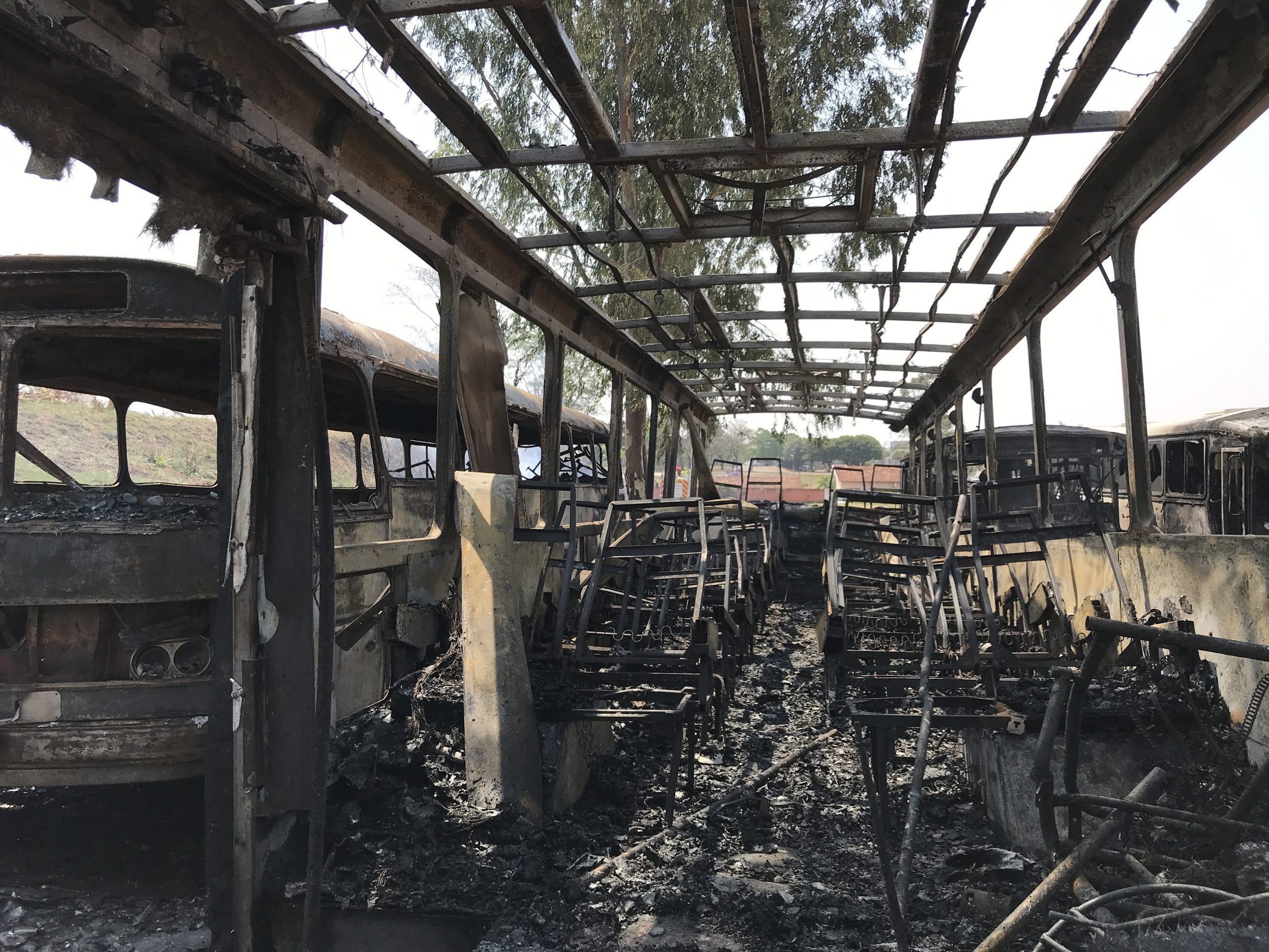 Ônibus ficam destruídos após incêndio em vegetação na linha férrea