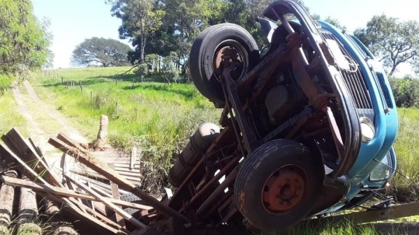 Ao passar em ponte de madeira, estrutura cede e caminhão cai em córrego